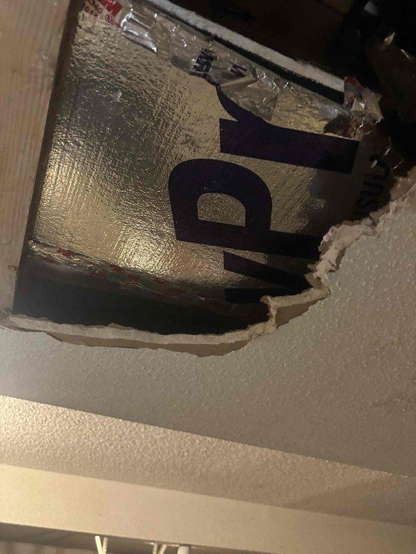 Responded to reported water leak occurring during washing machine operation. Upon arrival, conducted thorough inspection of plumbing system and identified source of water intrusion affecting ceiling and subfloor areas. 

Investigation revealed compromised drainage system with visible water damage to ceiling drywall and underlying structural components. Created access opening in ceiling to assess extent of damage and locate leak source. Inspection of crawlspace revealed deteriorated materials, moisture accumulation, and evidence of prolonged water exposure affecting wooden subfloor components and surrounding areas.

Traced leak to washing machine drain line connection. Found improper drainage causing water backup during wash cycles, resulting in overflow conditions that penetrated ceiling and floor structures. White PVC drainage piping showed signs of stress and improper installation contributing to the backup issue.

Documented existing conditions with photographs showing ceiling damag
