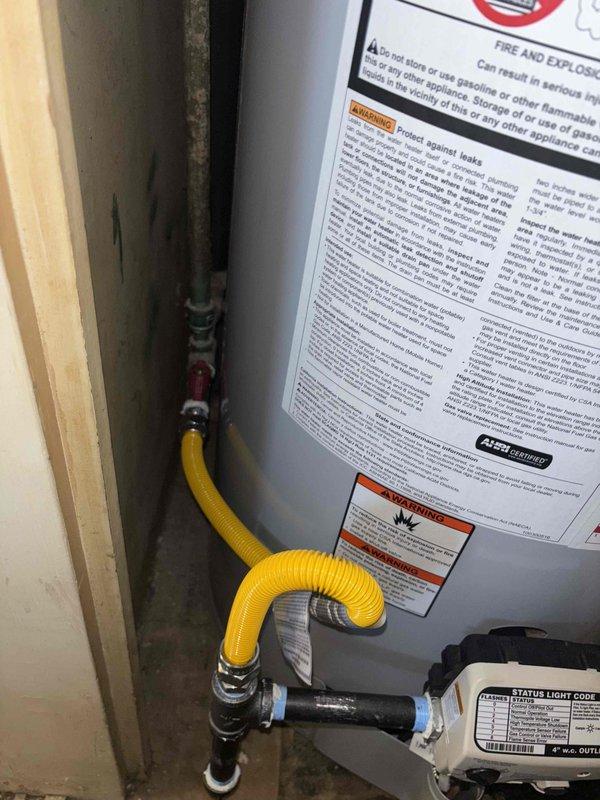 Completed installation of 40-gallon gas water heater with thermal expansion tank in residential utility space. Connected gas supply line using flexible yellow corrugated connector, installed proper venting ductwork, and made all necessary copper water line connections with shutoff valves. All safety labels verified in place, unit tested and operational.