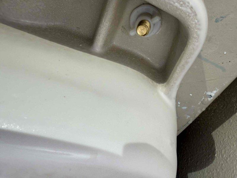 Responded to reported toilet leak penetrating ceiling into living room below and low hot water pressure at washing machine supply. Upon inspection, identified failed toilet mounting flange and supply line connection as source of water intrusion. Removed toilet, replaced wax ring seal and reinstalled closet bolts with proper mounting hardware to ensure watertight seal between fixture and drain pipe. Inspected washing machine hot water supply valve and determined restricted flow due to partially closed angle stop valve. Adjusted valve to full open position and verified restored water pressure to appliance. Confirmed no active leaks at toilet base and tested flush cycles to verify proper drainage and seal integrity.