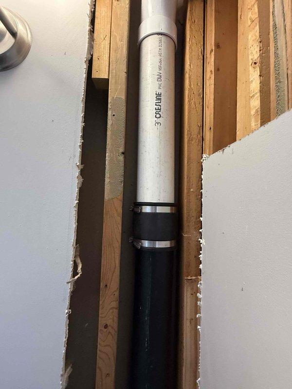 Accessed plumbing system through drywall removal in wall cavity and ceiling areas. Replaced damaged 90-degree fittings on 3-inch PVC pipe installation, including sections running through floor joists in upper bathroom area. Secured new pipe connections with stainless steel hose clamps and verified proper alignment of vertical drain line through wooden stud framing. Total repair time approximately three hours. Homeowner advised that drywall restoration is not included in plumbing scope of work.