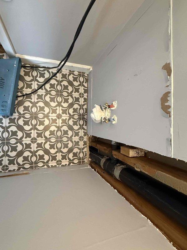 Accessed plumbing system through drywall removal in wall cavity and ceiling areas. Replaced damaged 90-degree fittings on 3-inch PVC pipe installation, including sections running through floor joists in upper bathroom area. Secured new pipe connections with stainless steel hose clamps and verified proper alignment of vertical drain line through wooden stud framing. Total repair time approximately three hours. Homeowner advised that drywall restoration is not included in plumbing scope of work.