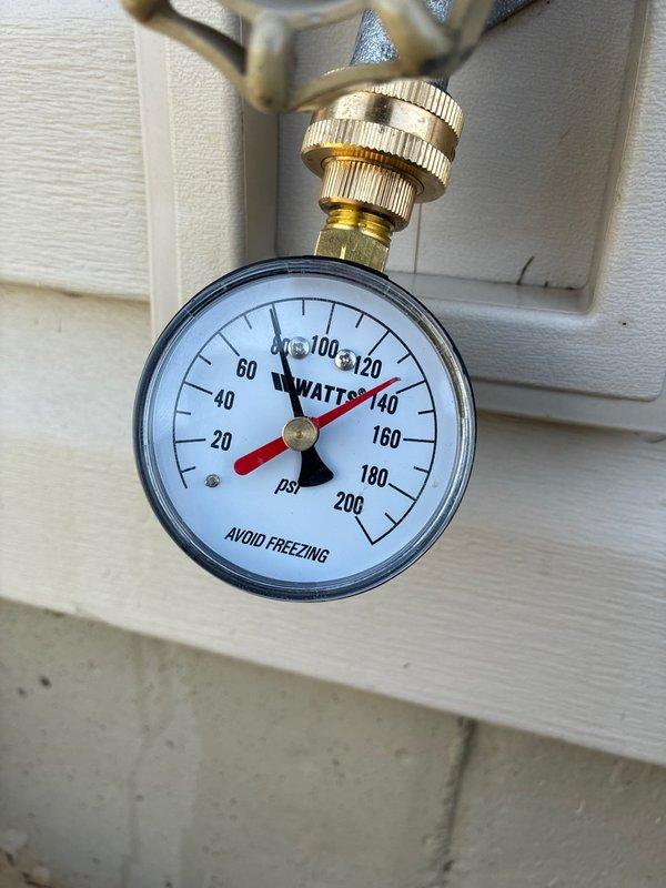 Responded to report of water leaking from tanked water heater in basement. Upon arrival, conducted thorough inspection of the water heater system and associated plumbing components. Identified issues with the water supply system requiring attention to pressure regulation and control valve assembly.

Inspected and verified proper operation of the building's water pressure regulation system, confirming the WATTS pressure gauge reading approximately 100 psi. Examined the complete plumbing manifold assembly including brass fittings, control valves, and pressure regulator mounted on the supply line. Assessed condition of blue CPVC piping connections and multiple brass T-joints, elbow fittings, and shutoff valves with black handles throughout the system.

Addressed the reported leak condition and ensured all connections were secure and functioning properly. Verified proper pressure settings and confirmed all control valves were operational. Documented system configuration including pressure 