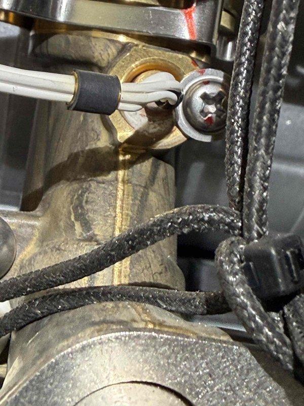 Responded to no hot water complaint in basement. Upon inspection, found tankless water heater with faulty gas valve assembly requiring immediate attention. Disassembled and serviced brass valve connections, which showed significant mineral buildup and oxidation affecting proper operation. Cleaned valve components, replaced worn terminal connections on white insulated wire assembly, and tested gas flow to ensure proper function. Unit restored to full operational status with hot water delivery confirmed.