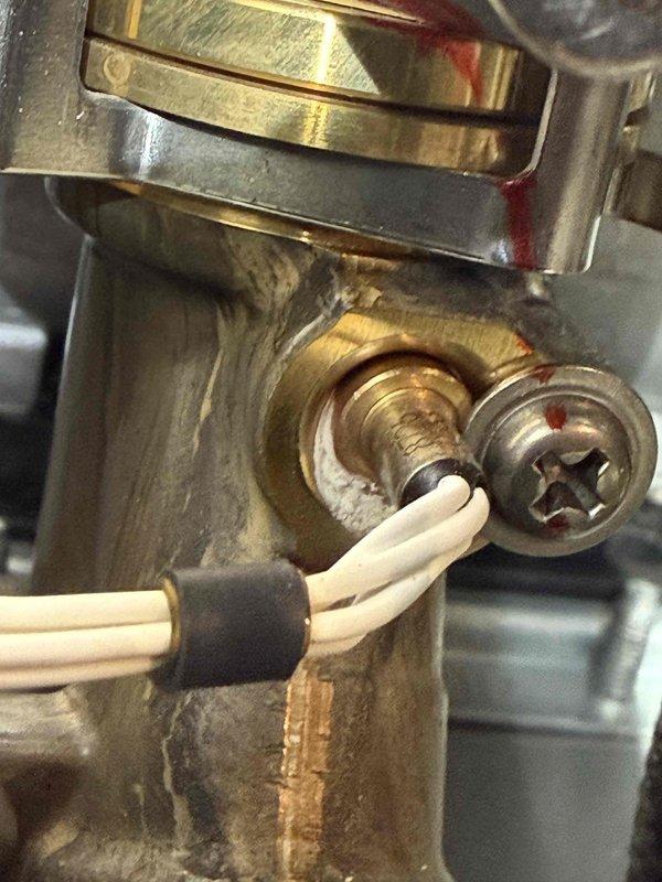 Responded to no hot water complaint in basement. Upon inspection, found tankless water heater with faulty gas valve assembly requiring immediate attention. Disassembled and serviced brass valve connections, which showed significant mineral buildup and oxidation affecting proper operation. Cleaned valve components, replaced worn terminal connections on white insulated wire assembly, and tested gas flow to ensure proper function. Unit restored to full operational status with hot water delivery confirmed.