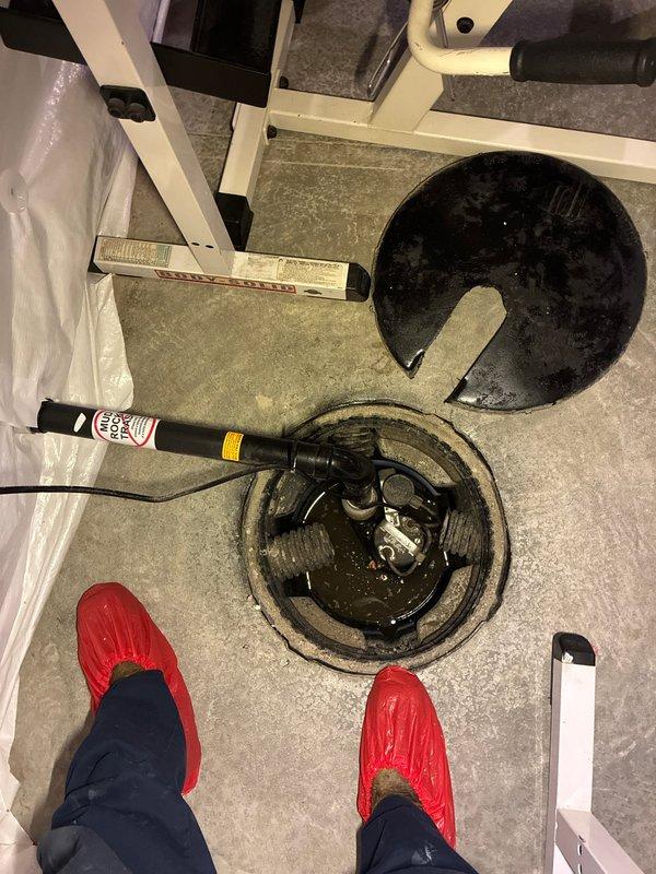 Conducted an on-site evaluation of an existing sump pump system in a basement to provide an estimate for adding a battery backup unit. Inspected the current submersible sump pump installation within the concrete sump pit, assessed the electrical connections, and evaluated the workspace conditions including proper containment measures with plastic sheeting. Documented the existing pump configuration, discharge piping, and pit dimensions to determine compatibility and requirements for integrating a battery backup system to ensure continued operation during power outages.