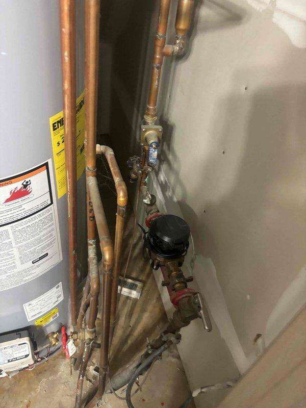 Responded to no hot water complaint at residential property. Upon arrival, inspected tanked water heater located in utility closet. Performed diagnostic evaluation of unit and associated plumbing connections. Examined copper supply lines, pressure relief valve, and gas control components. Assessed water heater's operational status and identified cause of hot water failure. Documented existing conditions including visible wear on piping system, connection points, and water heater cabinet. Provided repair recommendations to restore hot water service to the home.
