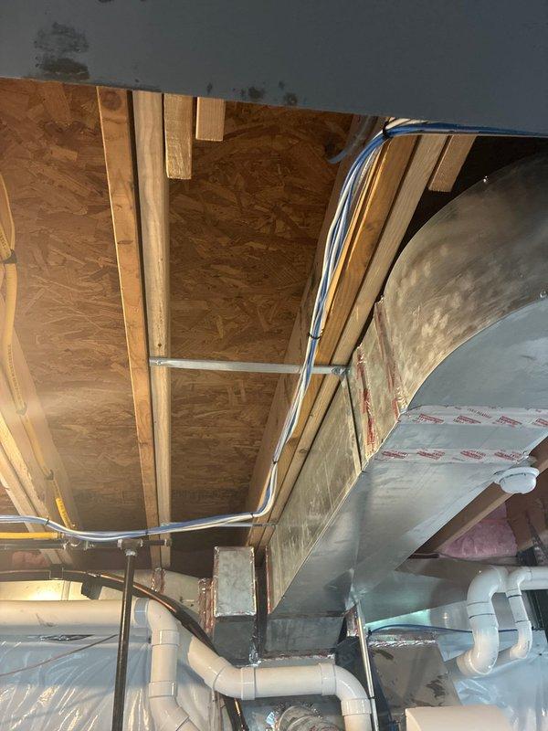 Responded to service call for gas line installation for dryer appliance. Completed installation of gas supply line with proper fittings and connections to accommodate dryer hookup. Verified all connections for proper seal and tested system for leaks using approved detection methods. Documented installation with photographs showing completed work in utility area with exposed mechanical systems and ductwork visible in attic space.