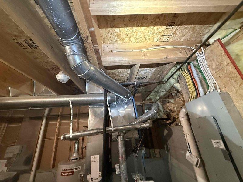 Completed preventive plumbing maintenance inspection in basement utility area. Inspected exposed plumbing lines, including copper piping and gas lines running along ceiling joists and wall framing. Verified proper support and routing of all visible water supply and drain lines in unfinished space. Checked for signs of leaks, corrosion, or deterioration on accessible piping systems. Confirmed clearances around HVAC ductwork and electrical panel to ensure no interference with plumbing infrastructure. All plumbing components found in satisfactory operating condition with no immediate repairs required.