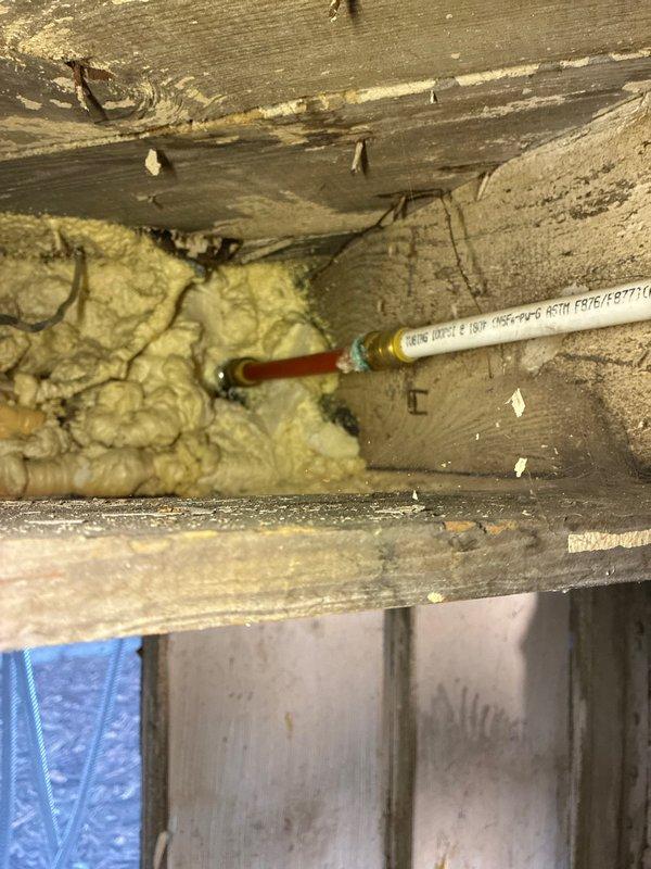 Responded to service call for multiple plumbing concerns including exterior faucet leaking into the house, washing machine supply line leak, and moisture at cast iron to PVC connection on main plumbing stack. Performed comprehensive inspection of all reported areas. Examined exterior hose bibb and traced water intrusion path. Inspected washing machine supply valves with red and blue handles mounted in wall box, noting aged flexible braided supply lines and surrounding PVC drainage system. Assessed main drain stack connection where cast iron transitions to PVC piping, documenting moisture concerns at joint. Photographed all problem areas including pipe connections, shut-off valves, drainage components, and structural conditions for documentation and repair planning. Provided assessment of existing conditions and discussed repair options with homeowner prior to proceeding with any corrective work per customer request.