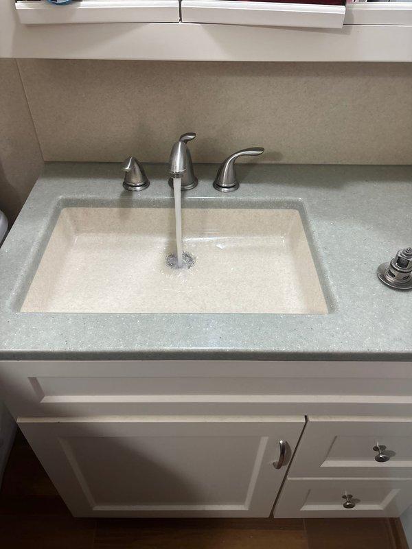 Responded to a clogged drain call at a basement bathroom sink in a split level home. Upon arrival, assessed the vanity-mounted sink with undermount basin and confirmed blockage in the drain line. Removed obstruction from the P-trap assembly beneath the sink, verified proper water flow through the drain system, and tested all plumbing connections for leaks. System restored to full functionality with water draining freely through the fixture.