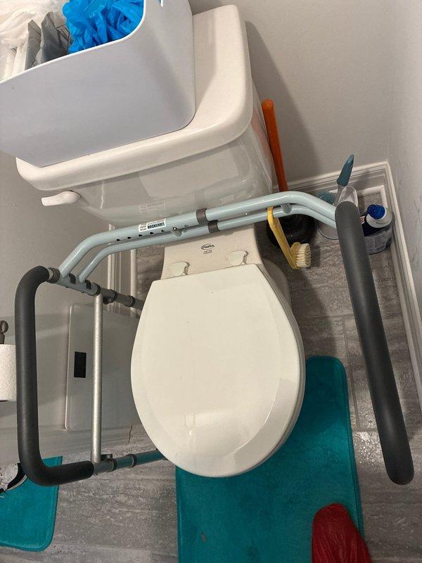 Responded to service call for toilet replacement estimate at residential property. Upon arrival, assessed existing standard white porcelain toilet in bathroom equipped with accessibility features including padded grab bars. Documented current fixture condition and surrounding bathroom configuration, noting gray vinyl plank flooring and adequate clearances. Evaluated installation requirements for potential replacement, including existing water supply line connection and floor flange accessibility. Photographed existing toilet and bathroom layout to provide accurate estimate for new fixture installation. Recommended replacement options based on bathroom dimensions and accessibility needs.