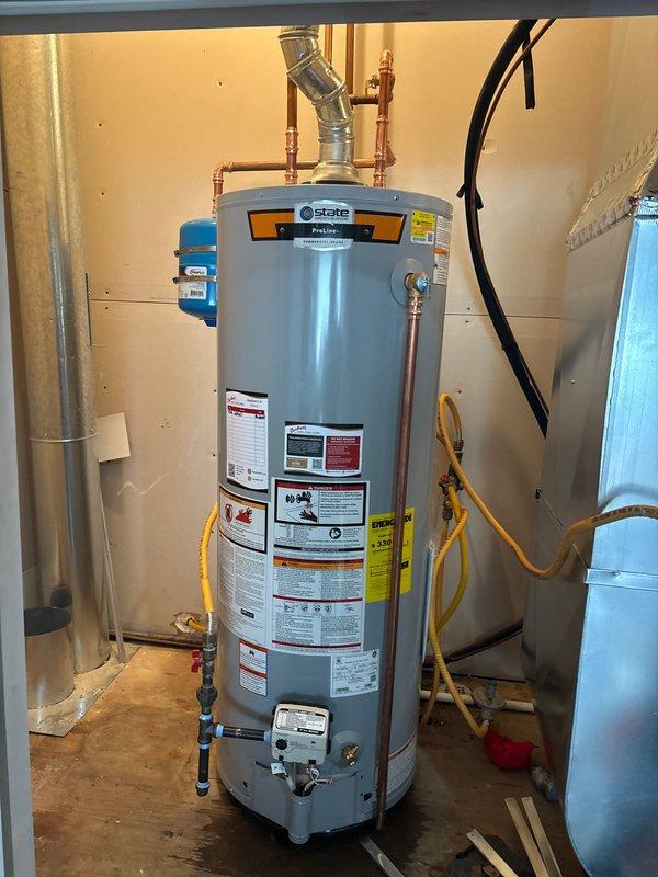 Completed installation of a 50-gallon State brand gas water heater in residential utility room. Removed existing unit and installed new tanked water heater with proper copper piping connections, brass fittings, and blue shutoff valve at top of unit. Connected gas supply lines using flexible yellow gas connectors and verified all connections for safety and code compliance. Installed vent piping system to exhaust combustion gases properly. Tested gas valve assembly and control panel functionality, confirmed proper ignition and temperature settings, and verified no gas leaks at all connection points. Ensured unit is level and stable on base, with all manufacturer labels and safety warnings visible. This installation was coordinated as part of a combination job with related HVAC work.