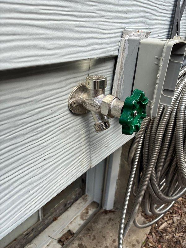 Replaced frost-free outside hose bib with new unit featuring cross-handle valve assembly mounted to exterior wall. Removed existing drywall around laundry area to access and replace failed laundry box with new code-compliant unit including pre-installed water hammer arrestors. Replaced leaking 1/2" PEX fittings at main supply lines and re-established connections to laundry box supply lines. Conducted pressure testing to verify all connections were leak-free and system was functioning properly.