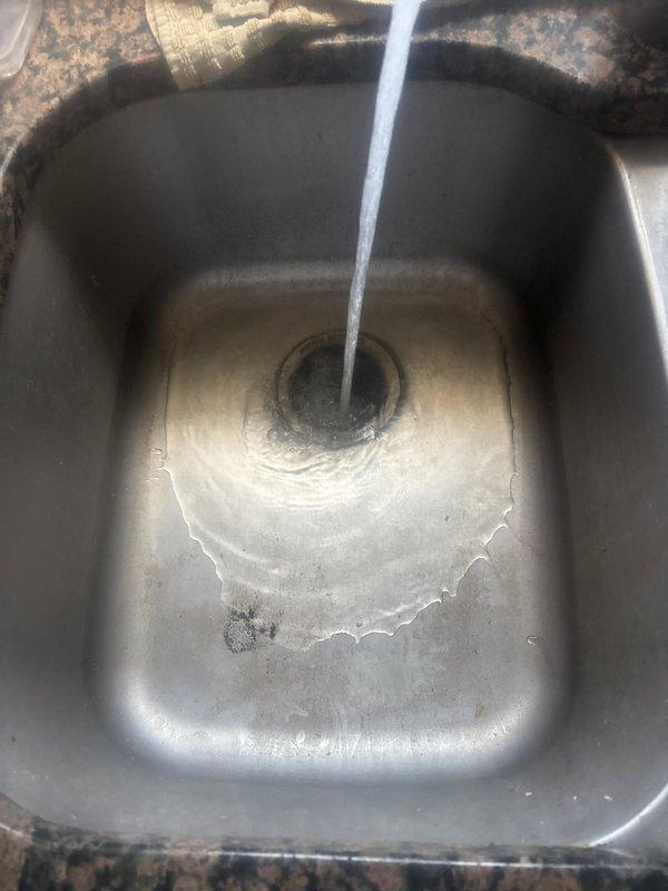 Responded to kitchen sink clog with garbage disposal unit. Upon arrival, assessed double-basin stainless steel sink installation and identified drainage obstruction in basin equipped with disposal. Cleared blockage from disposal unit and drain line, restoring proper water flow and drainage function. Tested both basins under running water to verify complete clearance and confirmed disposal operation. System returned to normal working condition with no further drainage issues observed.