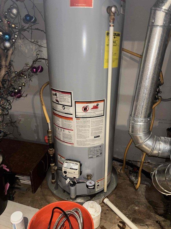 Completed plumbing maintenance inspection of crawl space and water heater installation. Inspected crawl space infrastructure including exposed floor joists, vapor barrier integrity, and plumbing penetrations; noted debris accumulation on moisture barrier requiring attention. Evaluated water heater condition, verified proper gas line connection with flexible yellow connector, confirmed adequate ventilation and clearances, and inspected water supply lines and discharge piping for proper installation and operation.