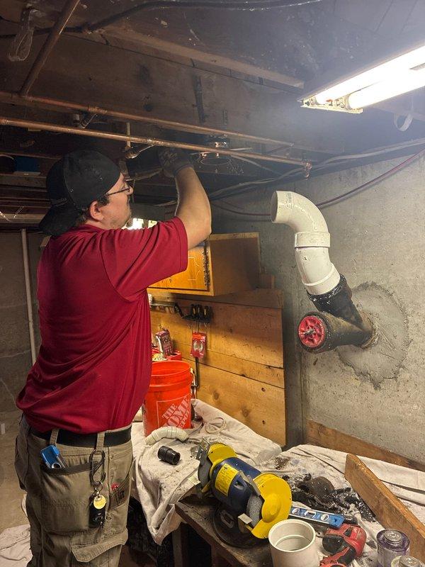 Completed a full repipe of main floor bathroom drainage system, removing deteriorated cast iron and galvanized piping. Removed toilet from flange and cut out cast iron back to the wye fitting at foundation wall. Carefully extracted cast iron from the hub while preserving the existing wye connection cast into the foundation. Installed a fernco hub adapter to transition from cast iron to PVC at the hub connection. Ran new PVC drainage piping to service the vent stack, bathtub drain, lavatory drain, and installed new toilet flange. Reinstalled the original toilet onto the new flange. Conducted comprehensive leak testing on all fixtures with water flow to verify integrity of new pipe runs. Removed all construction debris and materials from the workspace upon completion.