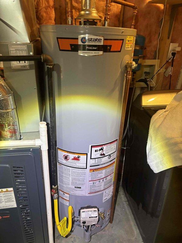 Performed plumbing maintenance inspection on State ProLine Commercial Grade water heater in residential mechanical room. Documented unit condition with photographs showing proper copper piping connections, gas line with yellow-handled shut-off valve, and white gas control valve at base. Interior inspection revealed orange-colored residue and moisture accumulation within cylindrical component, indicating potential sediment buildup or condensation requiring monitoring.