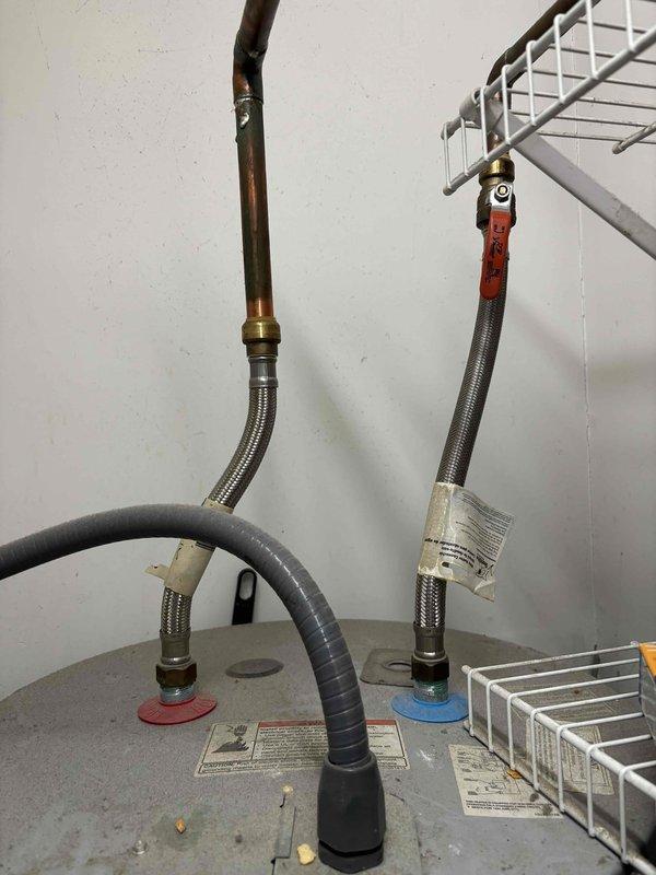 Responded to no hot water complaint at two bedroom condo unit. Upon arrival, inspected tanked water heater system and associated plumbing connections. Found water heater with compromised heating element requiring immediate attention. Observed corroded copper supply lines and deteriorating flexible connectors showing signs of age and mineral buildup. Documented existing conditions including discolored piping and worn insulation on system components. Performed diagnostic assessment of heating system, inspecting internal components and testing functionality. Identified failed heating element as primary cause of no hot water production. Recommended necessary repairs to restore hot water service to the residence.