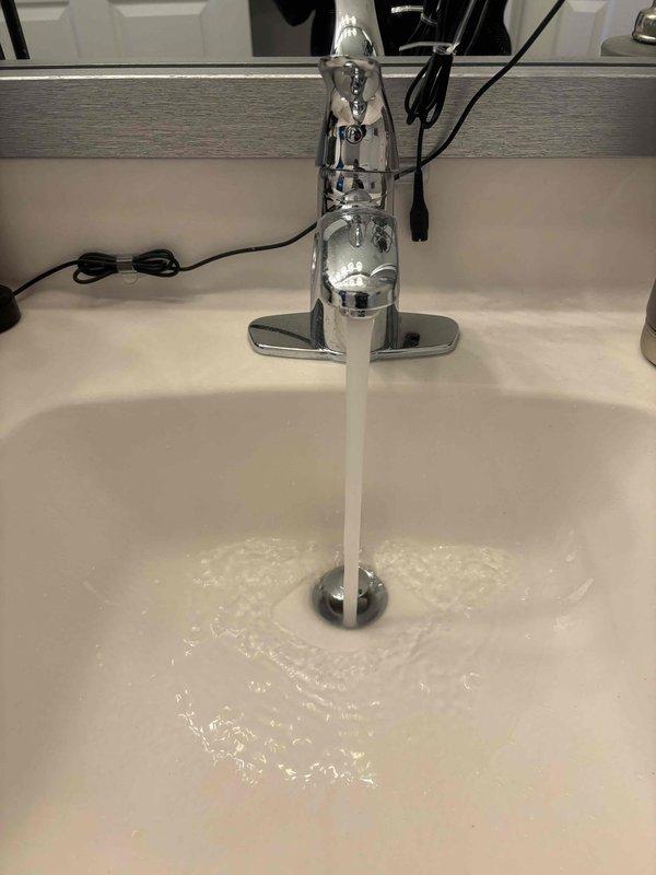 Completed plumbing maintenance visit to inspect and verify proper operation of bathroom sink faucet and associated supply and drainage systems. Tested water flow and pressure at chrome single-handle faucet, confirmed proper drainage through P-trap assembly, and inspected under-sink plumbing connections including flexible braided supply lines, shut-off valves, and PVC drain components to ensure all fixtures were functioning correctly without leaks.