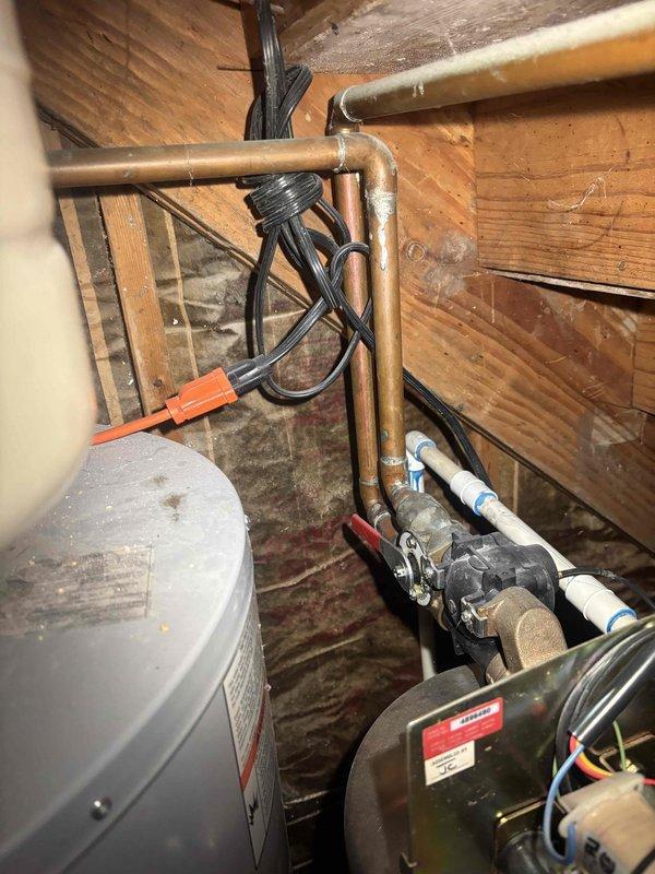 Conducted estimate for servicing Puronics water softener system located in basement utility area. Inspected water treatment equipment including stainless steel brine tank, softener resin tank, and associated plumbing connections with copper supply lines and PVC drainage piping. Assessed system condition, documented current installation configuration, and identified service requirements for proper water softening operation.