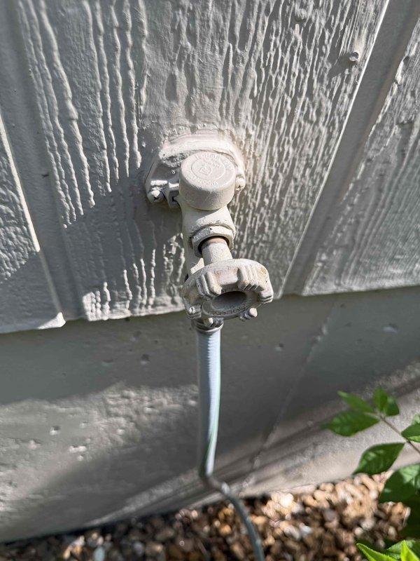 Responded to multiple water leak issues including an exterior hose bib with valve leakage, a garage shut-off valve experiencing dripping when activated, and a deteriorated three-inch black drain pipe beneath a sink that had been leaking for an extended period. Inspected and documented the outdoor spigot assembly showing weathered valve components and the basement drainage system exhibiting significant mineral buildup and corrosion around the pipe opening. Assessed all affected areas and provided repair recommendations to address the active leaks and prevent further water damage.