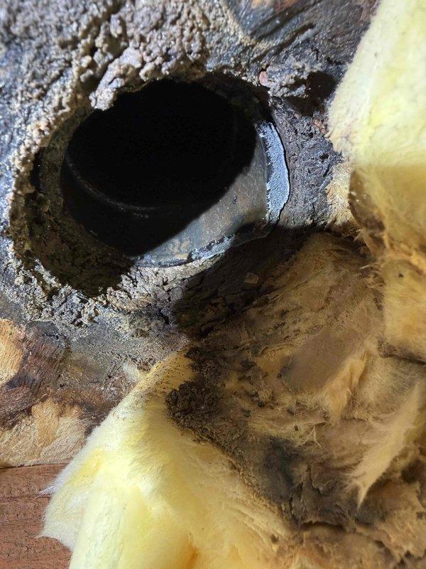 Responded to multiple water leak issues including an exterior hose bib with valve leakage, a garage shut-off valve experiencing dripping when activated, and a deteriorated three-inch black drain pipe beneath a sink that had been leaking for an extended period. Inspected and documented the outdoor spigot assembly showing weathered valve components and the basement drainage system exhibiting significant mineral buildup and corrosion around the pipe opening. Assessed all affected areas and provided repair recommendations to address the active leaks and prevent further water damage.