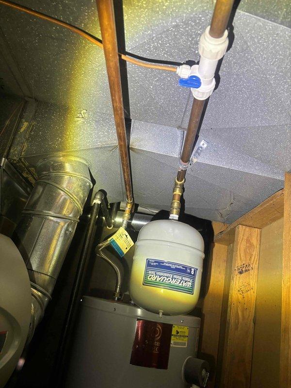 Completed preventive plumbing maintenance inspection of residential water heater and sump pump system. Inspected water heater tank, copper supply lines, pressure relief valve, and associated plumbing connections for proper operation and signs of wear. Examined sump pump assembly including motor, float switch mechanism, and discharge system; noted existing mineral buildup and staining consistent with normal operation but requiring future monitoring.