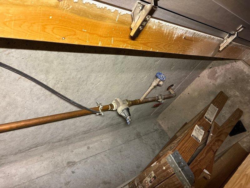 Completed on-site assessment of existing 20+ year old Freedom brand water heater located in basement utility area. Unit currently operational but nearing end of service life. Documented existing installation including copper supply lines with brass fittings, blue flexible water line connections, PVC drain line, and metal condensate pan positioned beneath unit. Water heater installed against framed wall with fiberglass insulation. Inspected supply line routing from basement through upper floor space, noting copper piping with shutoff valves and directional fittings. Provided comprehensive estimate for water heater replacement. Additionally assessed property for whole-house water filtration system installation and provided separate estimate for filtration equipment and installation.