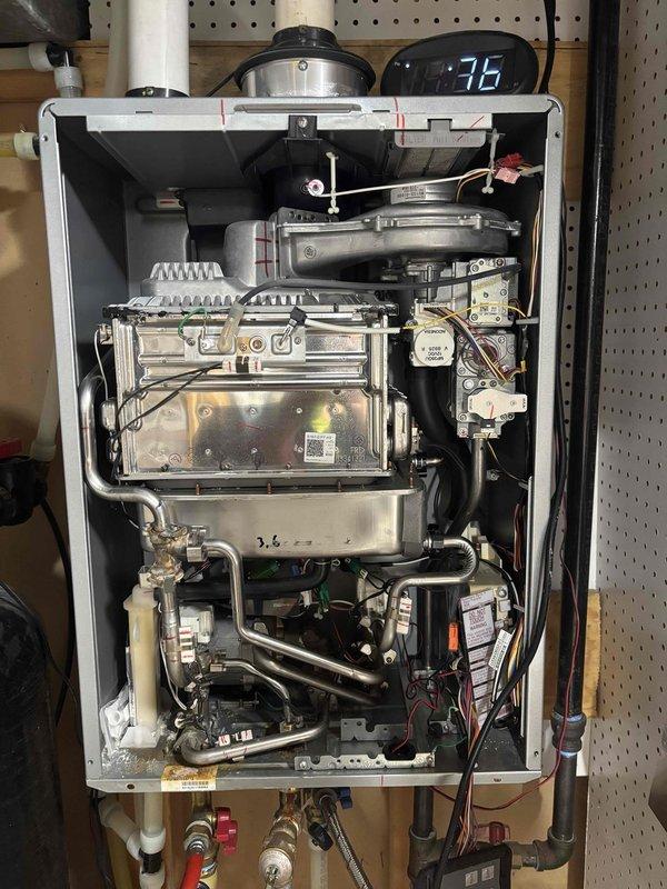 Technician responded to address water heater leaking and water softener malfunction. Performed comprehensive repair on tankless water heater unit, replacing all deteriorated O-rings at connection points and leak-affected components. Installed new temperature and pressure relief valve with mounting bracket to ensure proper safety operation. 

Upon inspection of the Puronics water softener system, hardness reagent testing revealed complete failure of the softening process, with water immediately turning dark blue indicating no treatment was occurring. Performed carbon media swap-out on the softener unit to restore proper water conditioning functionality. Removed front access panel of tankless unit to access internal heat exchanger, gas valve assembly, and plumbing connections. Verified all pipe connections, including copper and PVC inlet/outlet lines, were properly sealed following O-ring replacement. Tested igniter assemblies and flame sensors for proper operation. Confirmed all electri