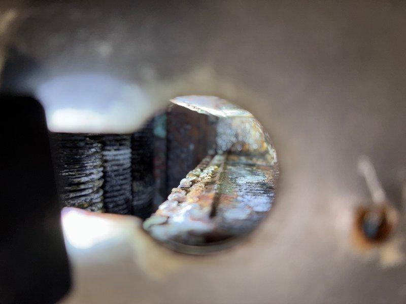 Responded to reported tankless water heater leak in basement. Upon inspection, identified corroded and deteriorated threaded connection as source of leak. The fastener displayed significant rust, oxidation, and thread degradation due to prolonged moisture exposure. Replaced failed component and secured all connections to restore proper operation and eliminate water leakage from the unit.