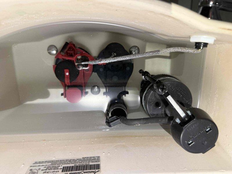 Performed plumbing maintenance on residential toilet system. Inspected internal tank components including flush valve assembly, fill valve mechanism, and refill tube connections. All components were functioning properly with flush valve, flapper, and ballcock assembly in good working condition. Verified proper water flow and tank refill operation.