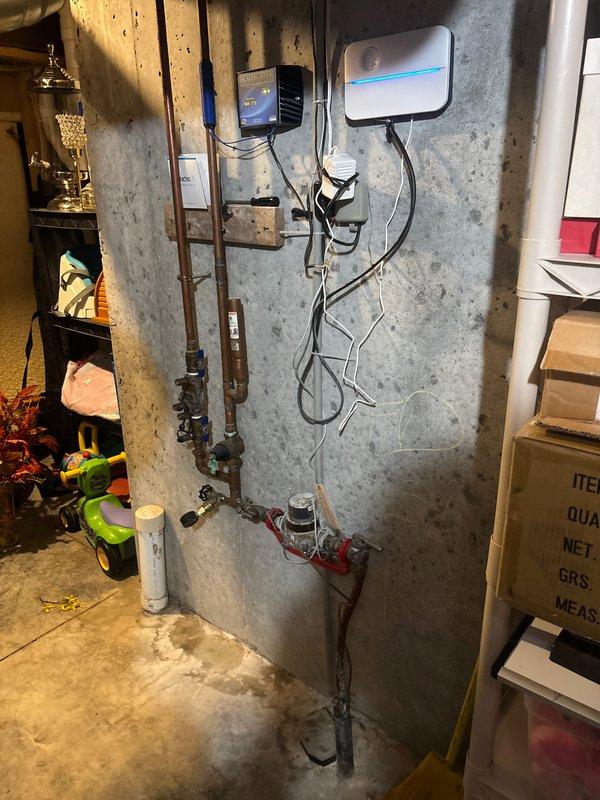Completed plumbing maintenance inspection at residential property, examining toilet supply line connections and main water distribution system in basement utility area. Inspected copper supply lines, shut-off valves, and control devices to ensure proper operation and verify system integrity with no leaks detected.