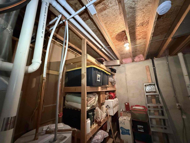 Conducted comprehensive evaluation of 10-year-old residential water heater located in basement utility area. Assessed existing unit's operational status, inspected copper supply lines, brass shut-off valves, metal flue venting system, and PVC drainage connections. Documented current installation configuration including all plumbing connections and clearances to provide accurate replacement estimate for new water heater installation.