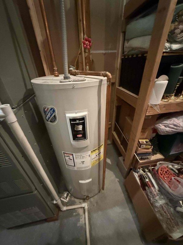 Conducted comprehensive evaluation of 10-year-old residential water heater located in basement utility area. Assessed existing unit's operational status, inspected copper supply lines, brass shut-off valves, metal flue venting system, and PVC drainage connections. Documented current installation configuration including all plumbing connections and clearances to provide accurate replacement estimate for new water heater installation.