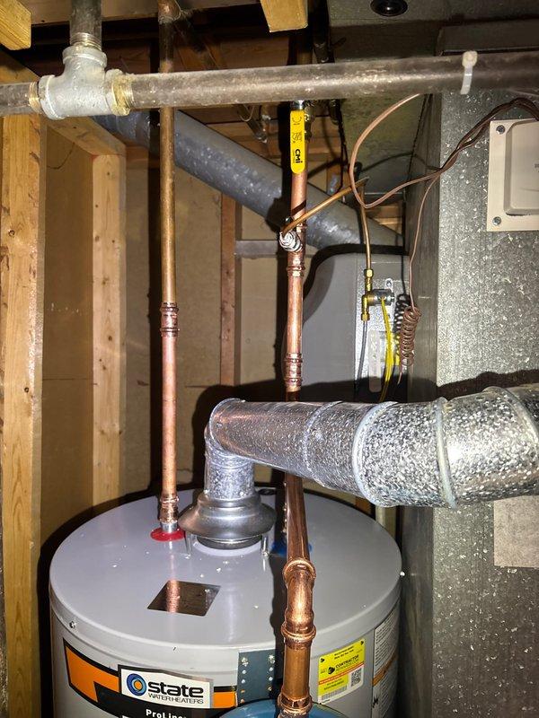 Completed installation of a 50-gallon State ProLine gas water heater in residential utility closet. Installed thermal expansion tank to protect plumbing system from excess pressure caused by thermal expansion during heating cycles. Configured all copper supply line connections with proper fittings and joints to ensure code-compliant water distribution. Connected gas supply line and established proper venting through existing ductwork infrastructure. Mounted expansion tank above water heater using appropriate brackets and connected to cold water supply line. Verified all connections for leaks, tested temperature and pressure relief valve operation, and confirmed proper gas combustion and venting. System tested and operational upon completion.