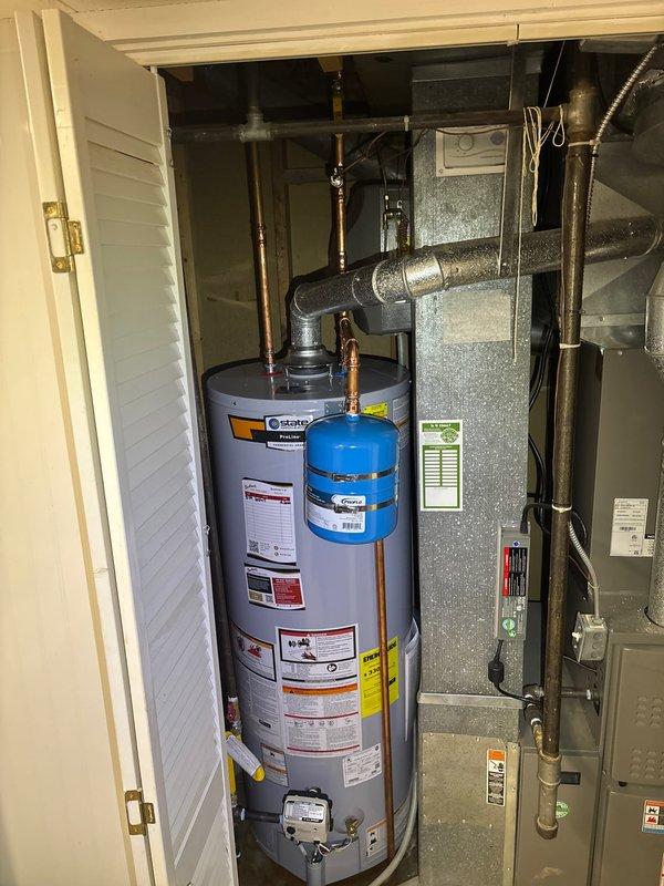 Completed installation of a 50-gallon State ProLine gas water heater in residential utility closet. Installed thermal expansion tank to protect plumbing system from excess pressure caused by thermal expansion during heating cycles. Configured all copper supply line connections with proper fittings and joints to ensure code-compliant water distribution. Connected gas supply line and established proper venting through existing ductwork infrastructure. Mounted expansion tank above water heater using appropriate brackets and connected to cold water supply line. Verified all connections for leaks, tested temperature and pressure relief valve operation, and confirmed proper gas combustion and venting. System tested and operational upon completion.