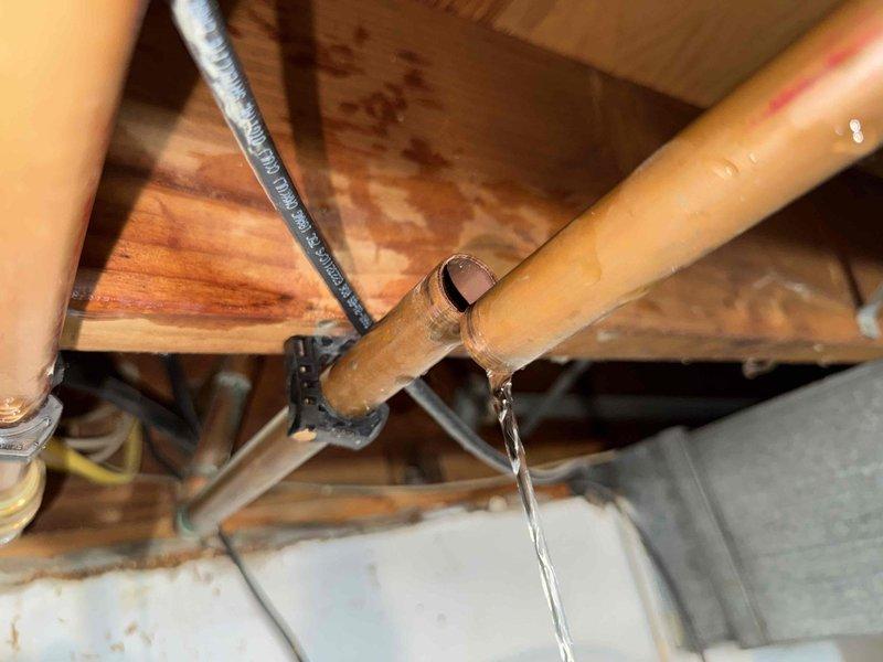 Responded to reported water leak in basement area. Upon inspection, located active leak from copper pipe in crawl space above basement ceiling. Water was actively streaming from compromised section of pipe near wooden structural beams and ductwork. Isolated water supply, removed damaged section of copper piping, and installed new copper fitting and pipe section. Tested system for proper water flow and verified complete seal with no additional leaks detected. Removed failed valve component and disposed of damaged materials.