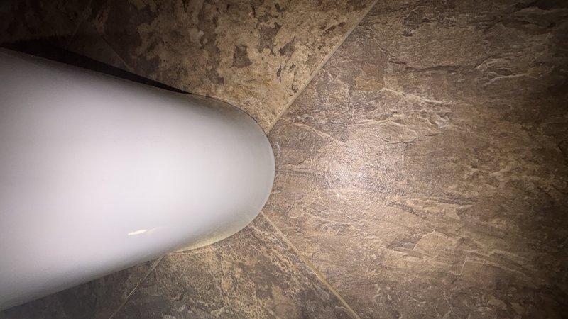 Responded to reported leak at base of toilet in downstairs bathroom. Conducted thorough inspection of toilet base, wax ring seal, and floor flange connections to identify source of water seepage. Documented existing conditions with photographic evidence showing moisture accumulation at toilet base and floor interface. Additionally, performed water purifier filter replacement as requested to maintain system efficiency and water quality standards.