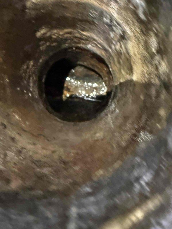 Responded to main drain cleanout service call in bathroom area. Upon arrival, performed thorough inspection of drain system and access points. Utilized professional drain cleaning equipment to clear the main line, removing accumulated debris including organic matter, fibrous material, and minor buildup from the pipe interior. Verified proper flow and drainage through the system following cleanout procedure. Line is now clear and functioning properly with no obstructions detected.