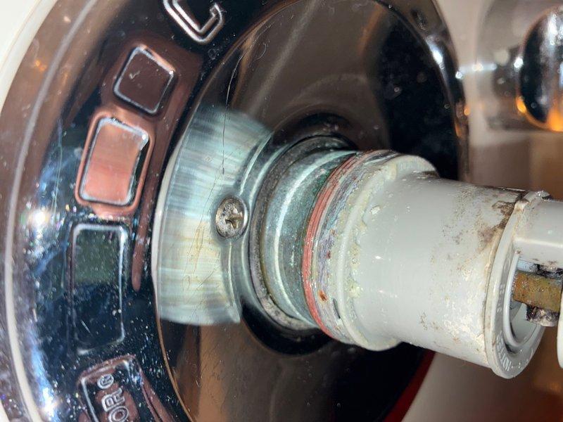 Responded to callback for low water pressure issue following recent water heater installation in garage utility closet. Upon inspection, identified corroded and deteriorating plumbing connections at shower valve assembly with visible mineral deposits and worn threading. Assessed water pressure throughout system and traced restriction to compromised fittings showing green and reddish-brown corrosion. Addressed connection integrity issues to restore proper water flow and pressure to affected fixtures.