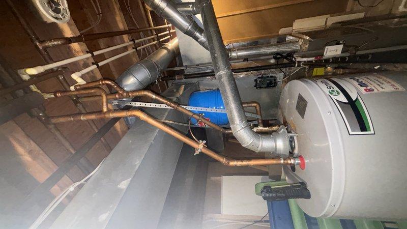 Completed installation of a State 50-gallon gas water heater with 6-year manufacturer warranty in basement utility area. Installed thermal expansion tank with copper piping connections to ensure proper system pressure regulation and code compliance. Replaced existing 3/4" ball valve on main water supply line and installed new 1/4 turn stop valve for humidifier connection. All copper pipe connections were secured with brass fittings, and gas connections were tested for leaks. System was filled, pressurized, and tested for proper operation. Verified adequate venting through existing PVC flue system and confirmed all safety controls functioning correctly. Provided customer with 1-year parts and labor warranty documentation.