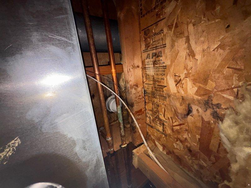 Responded to service call for reported water leak affecting garage ceiling. Conducted thorough leak location investigation to identify source of moisture intrusion. Upon inspection, traced water staining on ceiling to plumbing infrastructure located in space above garage. Examined copper supply lines and associated piping system in overhead area, identifying deteriorated conditions around plumbing penetrations and aged building materials that may be contributing to moisture issues. Documented leak source location and extent of water damage with photographic evidence. Provided assessment of necessary repairs to resolve active leak and prevent further water infiltration damage to ceiling surfaces and structure.