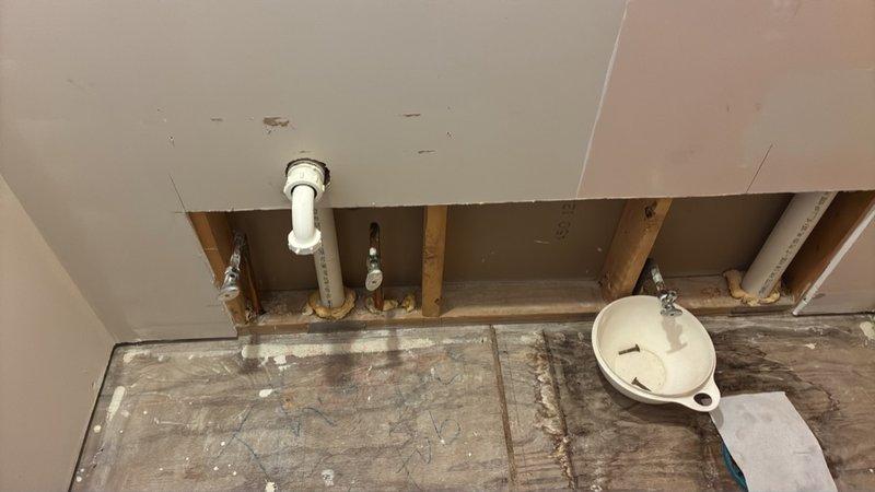 Conducted comprehensive assessment of existing plumbing infrastructure in two bathrooms to provide estimate for relocating waterlines. Inspection revealed exposed framing and PVC supply lines requiring rerouting through wall cavities and floor joists. Documented existing pipe locations, structural considerations, and necessary demolition points to facilitate waterline relocation during renovation project.
