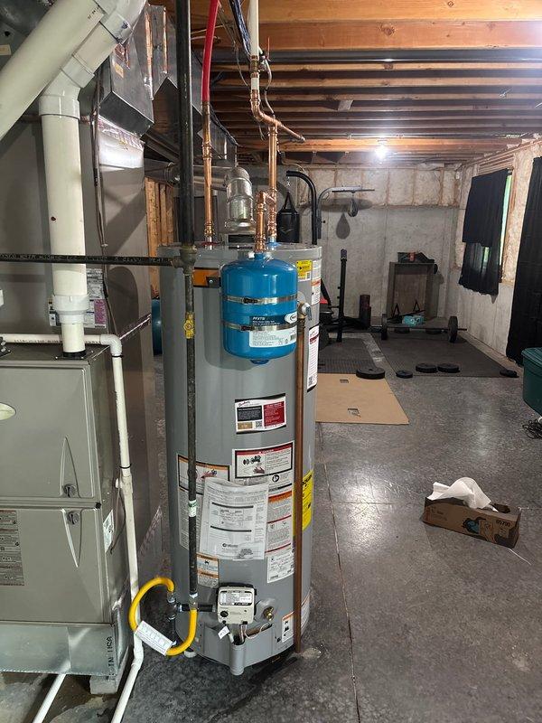 Installed a 50-gallon State gas water heater with thermal expansion tank in the basement utility area. Added a 3/4" ball valve and 1/4 turn stop for humidifier connection. All copper piping connections were completed to manufacturer specifications, and the unit was tested for proper operation with 6-year manufacturer warranty and 1-year parts and labor warranty coverage in effect.