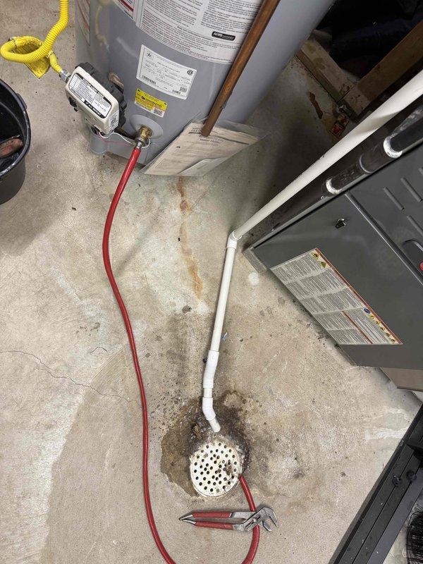 Performed routine maintenance flush on residential tanked water heater located in basement mechanical room. Drained sediment buildup from tank bottom through drain valve using hose directed to floor drain, cleared accumulated mineral deposits to restore heating efficiency and extend unit lifespan. Water heater and surrounding HVAC equipment confirmed in proper working condition upon completion.