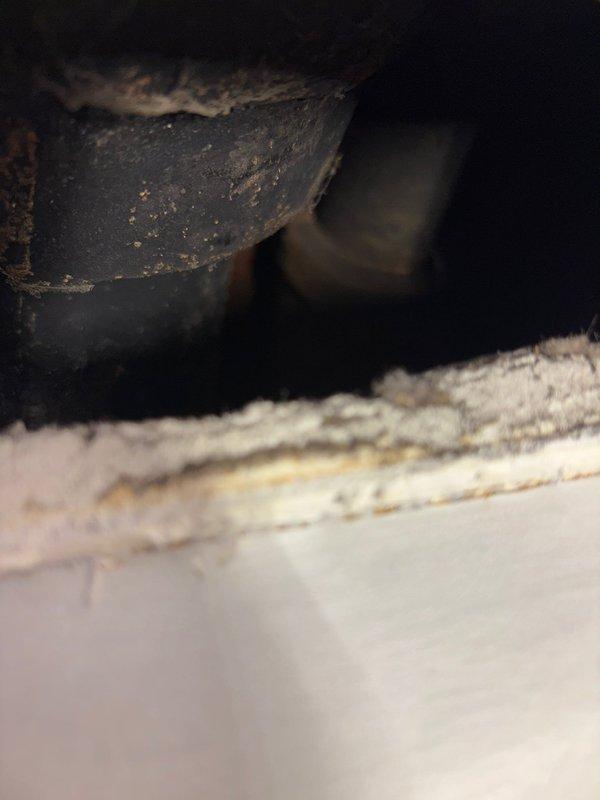 Responded to reported water leak in upstairs bathroom originating from either sink or toilet. Upon inspection, accessed under-sink cabinet area and examined plumbing configuration including PVC P-trap assembly, metal tailpiece, and chrome supply lines with shut-off valves. Investigated adjacent crawl space or wall cavity where deteriorated pipe work showed significant corrosion, rust patches, and aging metal surfaces. Completed diagnostic assessment and necessary repairs to resolve the leak issue.