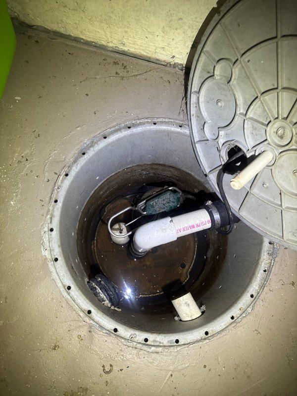 Responded to service call for non-operational sump pump system in residential basement. Upon inspection, found sump pump basin with standing water and malfunctioning pump mechanism. Assessed float switch assembly and pump components for proper operation. Identified issues with pump activation and drainage system performance. Inspected associated discharge piping including PVC outlet lines and corrugated drainage hose connections. Noted significant corrosion on secondary floor drain cover and water staining patterns on basement floor indicating previous drainage concerns. Evaluated sump pit liner, basin depth, and pump positioning. Restored sump pump to full working order, verified float switch operation, and tested pump cycle to ensure proper water evacuation from basin. Confirmed discharge lines were clear and functioning correctly upon completion.