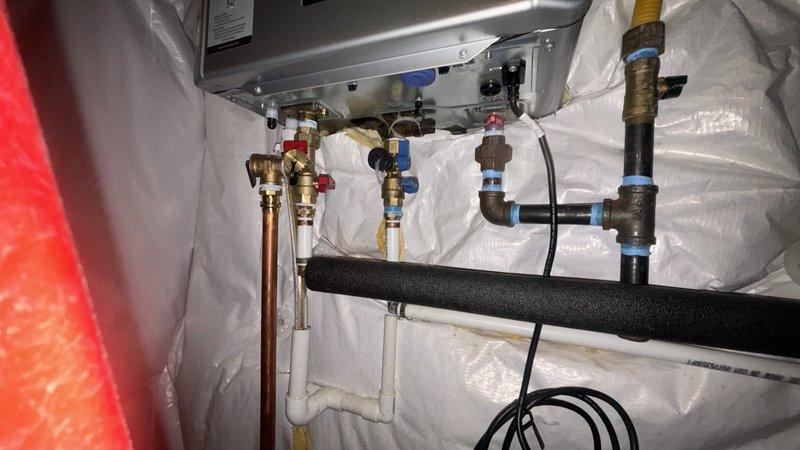 Completed warranty replacement of Rinnai tankless water heater unit per case #254181. Removed existing failed unit and installed new Rinnai tankless water heater in confined utility space, connecting all copper supply lines, brass shut-off valves, pressure relief valve, and PVC venting system. Verified all connections for proper operation and tested unit functionality upon completion.