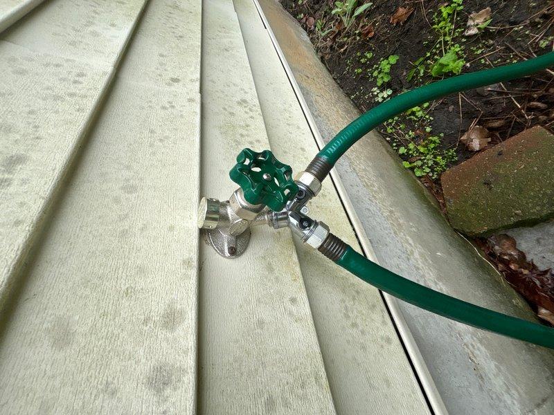Responded to emergency call regarding water leak from broken faucet in basement wall. Upon arrival, located source of leak at corroded copper pipe connection near foundation. Assessed exterior hose bib assembly and traced supply line to compromised joint showing significant oxidation and pink discoloration indicating active corrosion failure. Replaced damaged copper pipe section and coupling, secured all connections, and pressure-tested system to verify leak elimination. Exterior spigot assembly inspected and confirmed operational with garden hose attachment functioning properly.