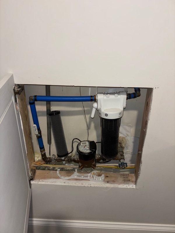 Performed scheduled maintenance on tankless water heater system, including complete descaling flush to remove mineral buildup and ensure optimal performance. Removed front access panel to access internal heat exchanger components, connected flushing equipment, and circulated descaling solution through the unit to eliminate calcium and sediment deposits from the heat exchanger fins and water pathways. Inspected water filtration system with dual black filter canisters to verify proper pre-filtration of incoming water supply, which helps extend the life of the tankless unit. Verified all inlet and outlet connections, including hot water supply line, cold water return, and gas line connections for proper sealing and operation. Restored unit to normal operating condition and confirmed proper functionality of digital control modules and venting system upon completion of maintenance service.